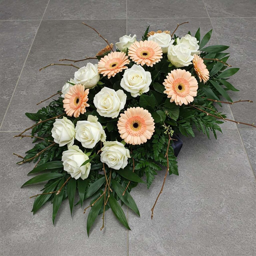 podłużna wiązanka na kremację z białych róż i kremowych gerberów